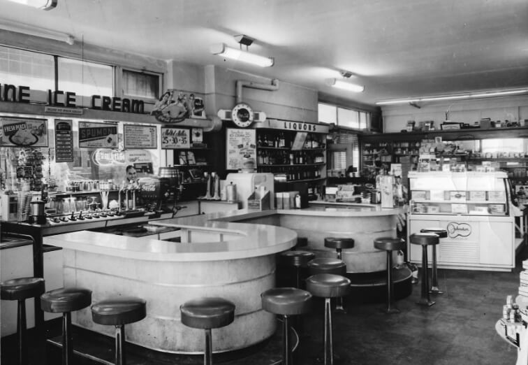 Black and white photo of original Fitzy's horseshoe counters with barstools